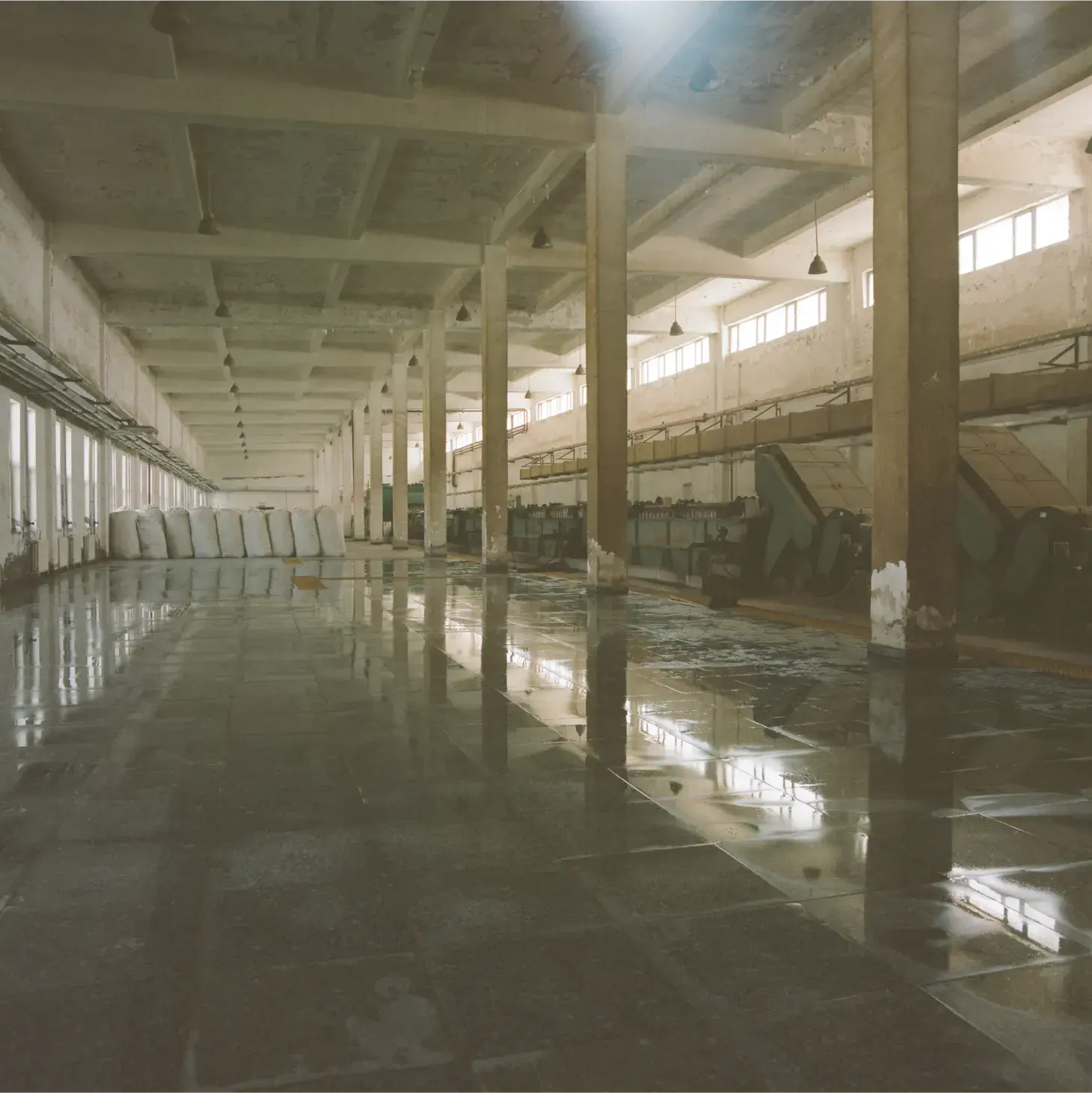 Empty factory floor with bags of wool in the background