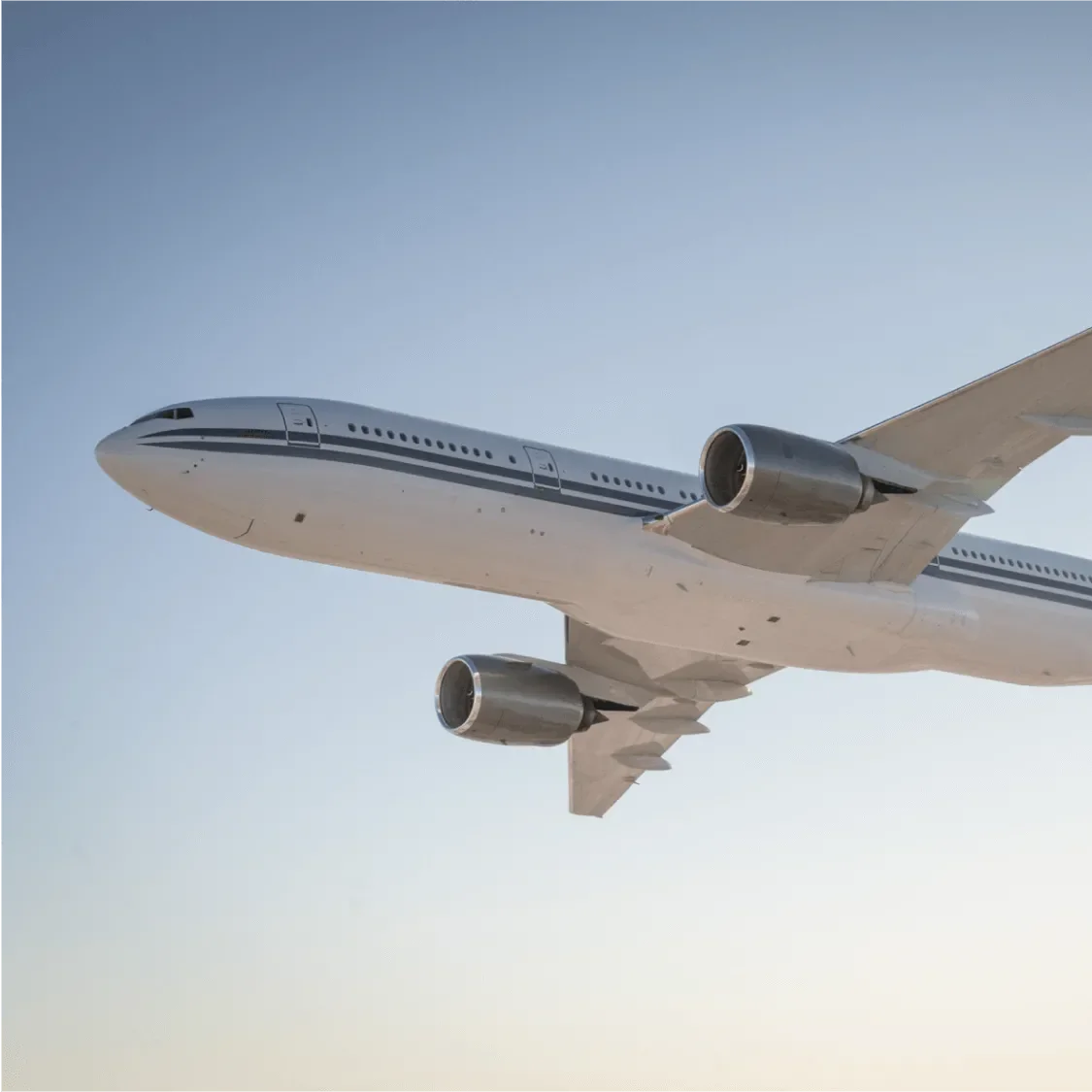 Boeing 777 flying against a blue sky