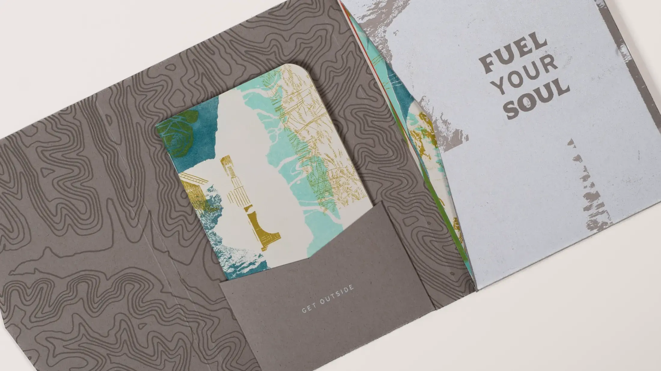 open packaging showing textured interior, booklet and postcards in pouch