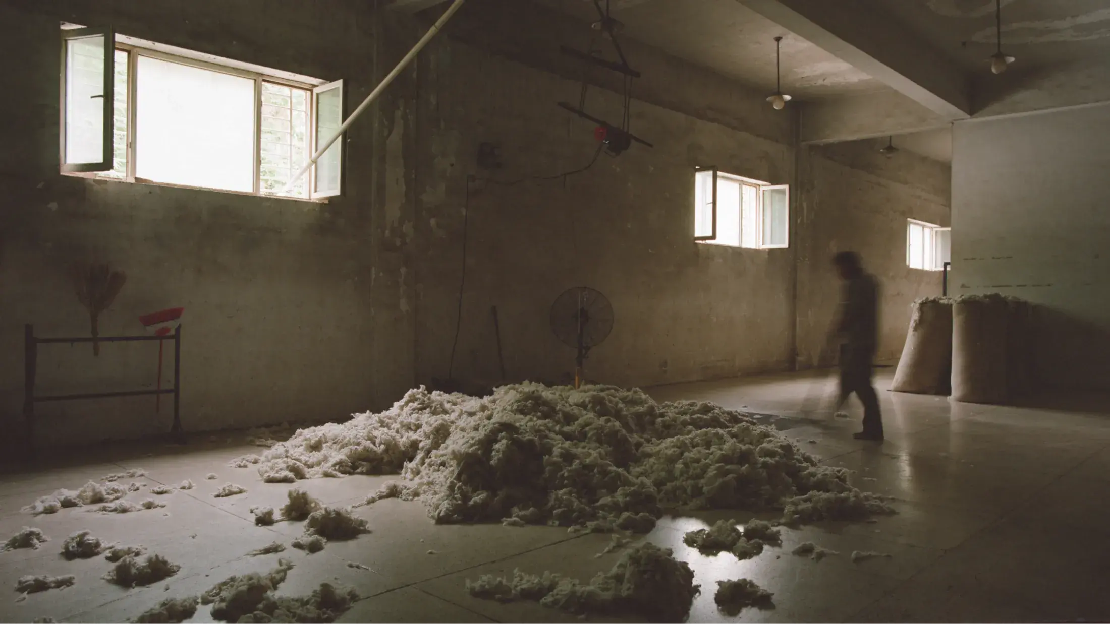 man sweeping a pile of wool