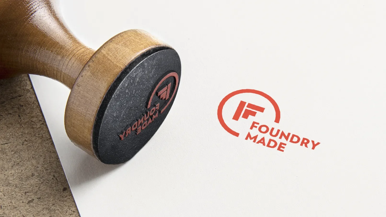 rubber stamp laying on its side with the idea foundry logo stamped in red ink on paper