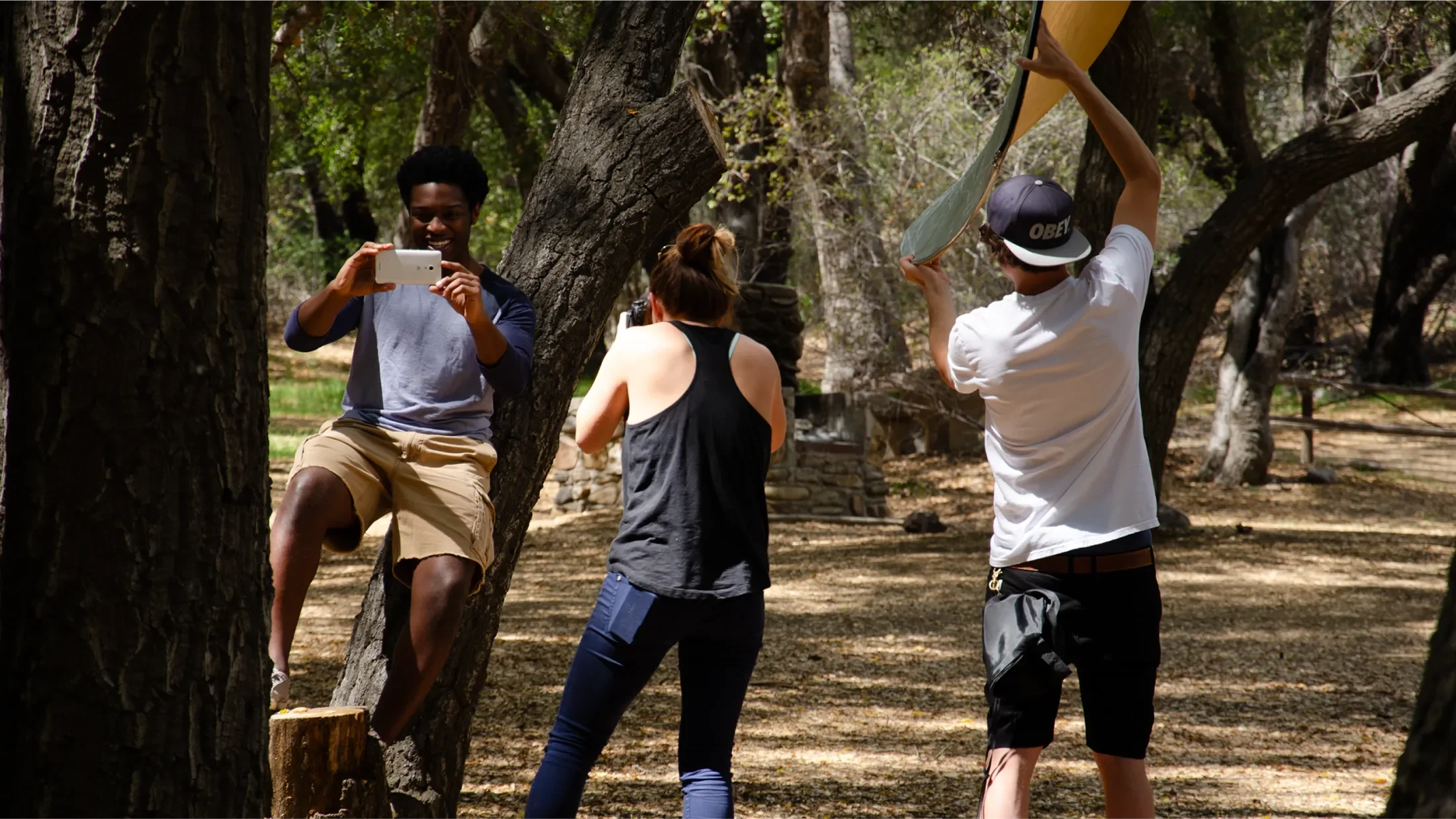 Behind the scenes of the Huawei photoshoot, a photographer is capturing a young adult taking a picture with his Ascend Mate2 while an assistant holds a diffuser behind them