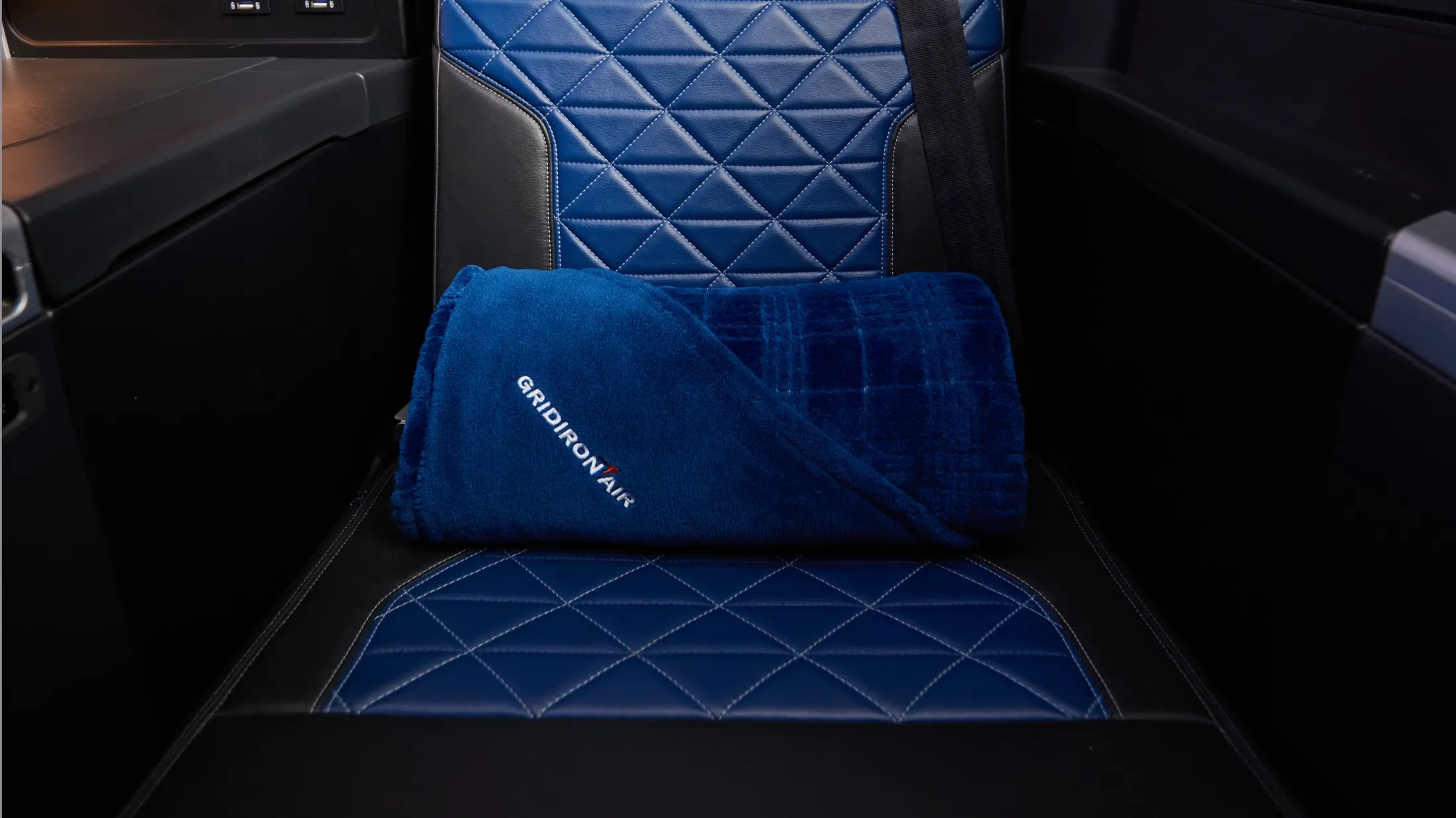 gridiron air branded navy blanket against an aircraft seat