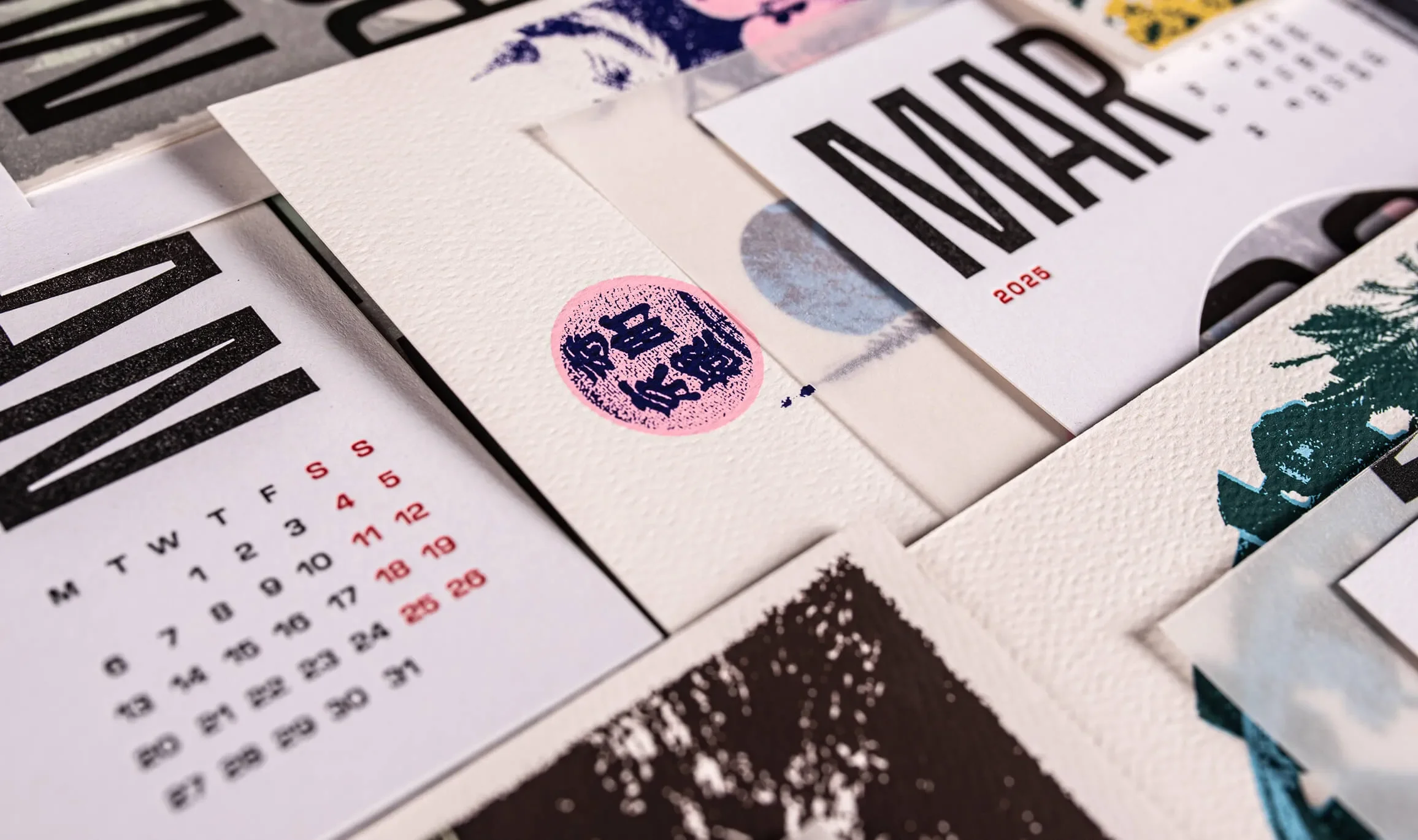 Month calendar cards and artwork arranged in a pile