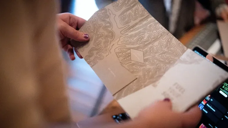 Woman holding the packaging open, showing the topographical map inside
