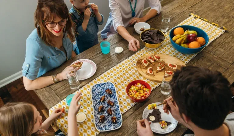 a group of friends sitting around a table enjoying snacks and Laughing Cow cheese