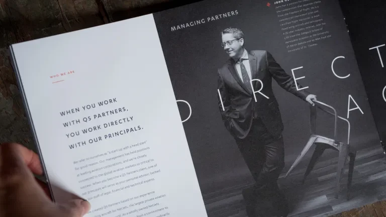 booklet page showing a man in a suit leaning on a chair, reads "When you work with QS Partners, you work directly with our principles."