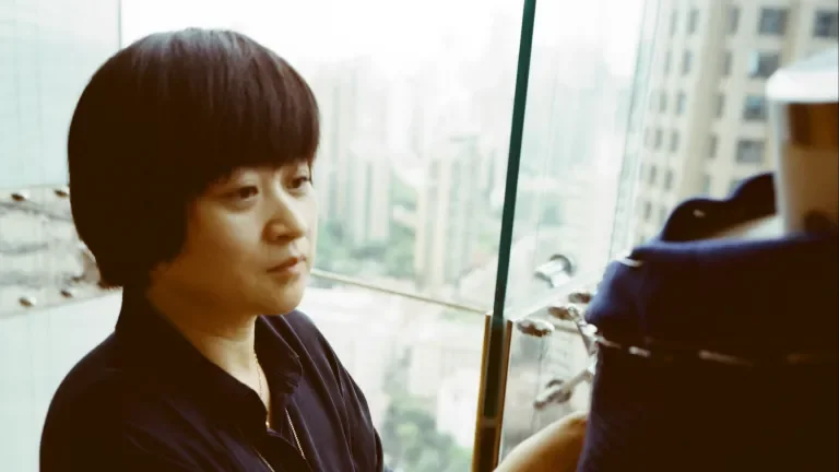 woman beside a window touching cashmere clothing