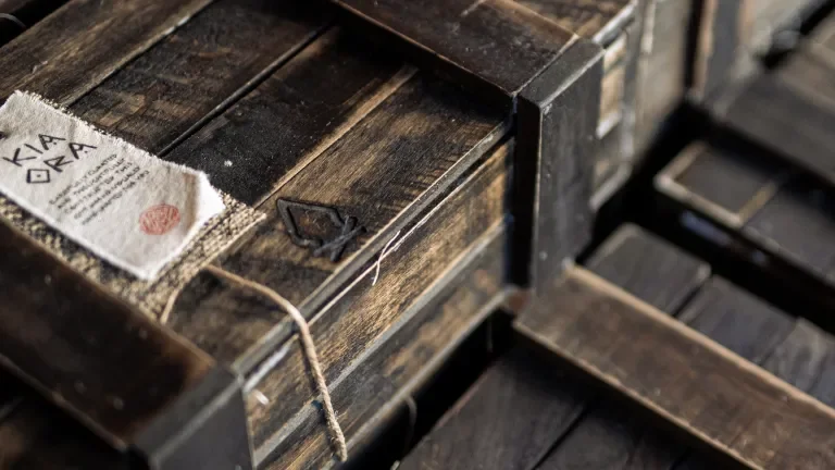 Exterior wooden packaging of the gift featuring a cloth tag held on by string and the Bonfire Red logo branded on the box