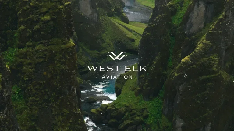 West Elk Aviation logo against a lush green mountainous background