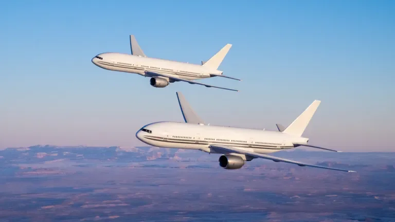 Two Boeing 777 flying against the horizon