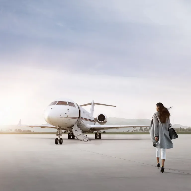 Well-dressed woman walking toward plane during sunrise