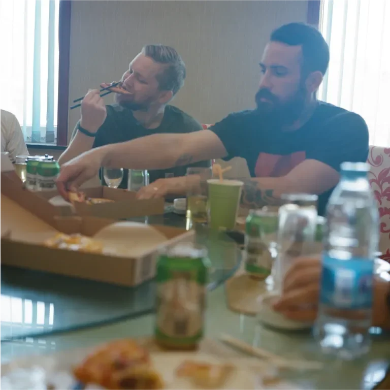 two men sharing pizza at a table