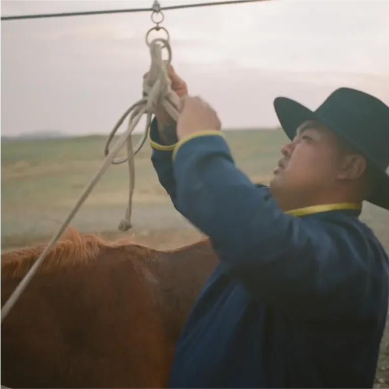 man tying a knot to a hanging rope