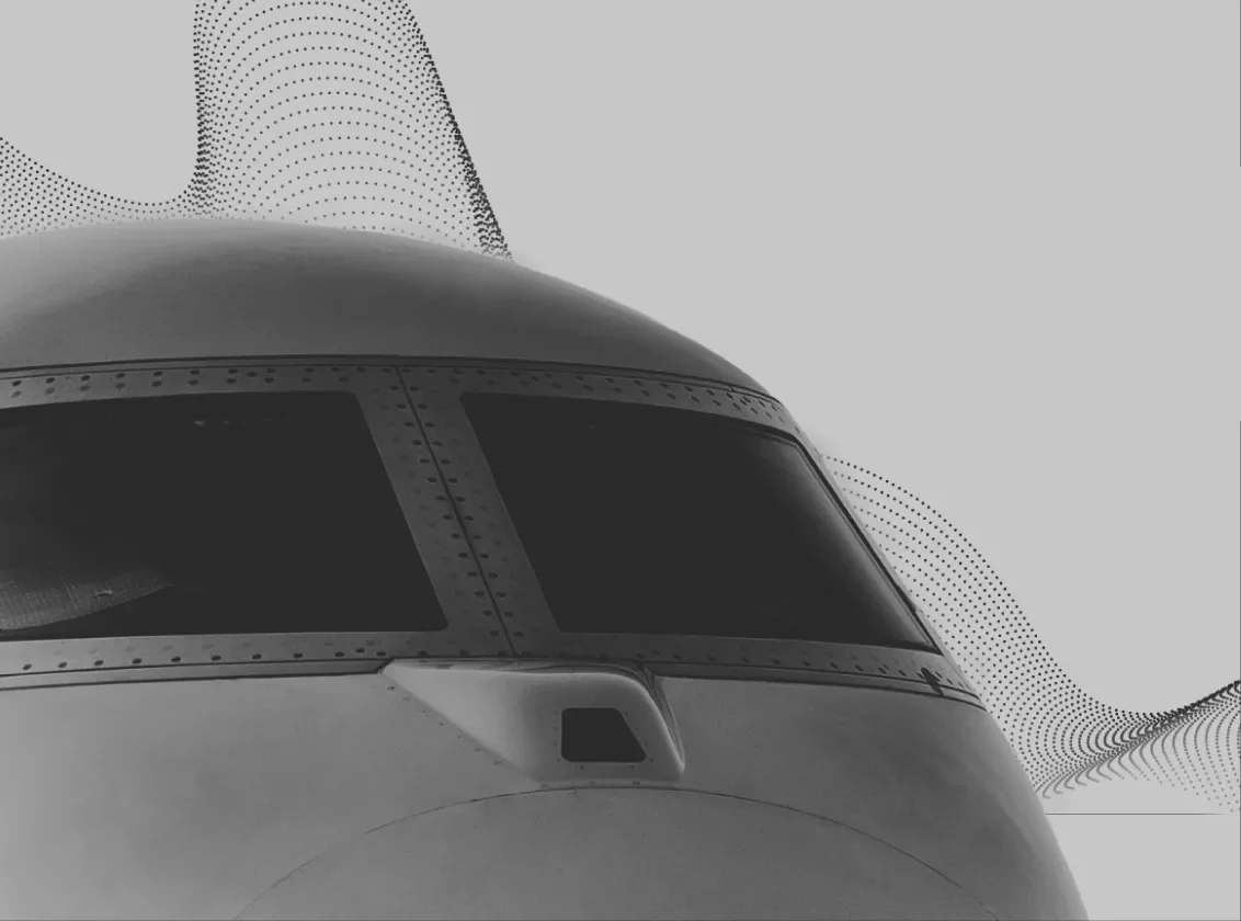 Exterior of a plane cockpit in black and white with a dotted wave pattern behind it