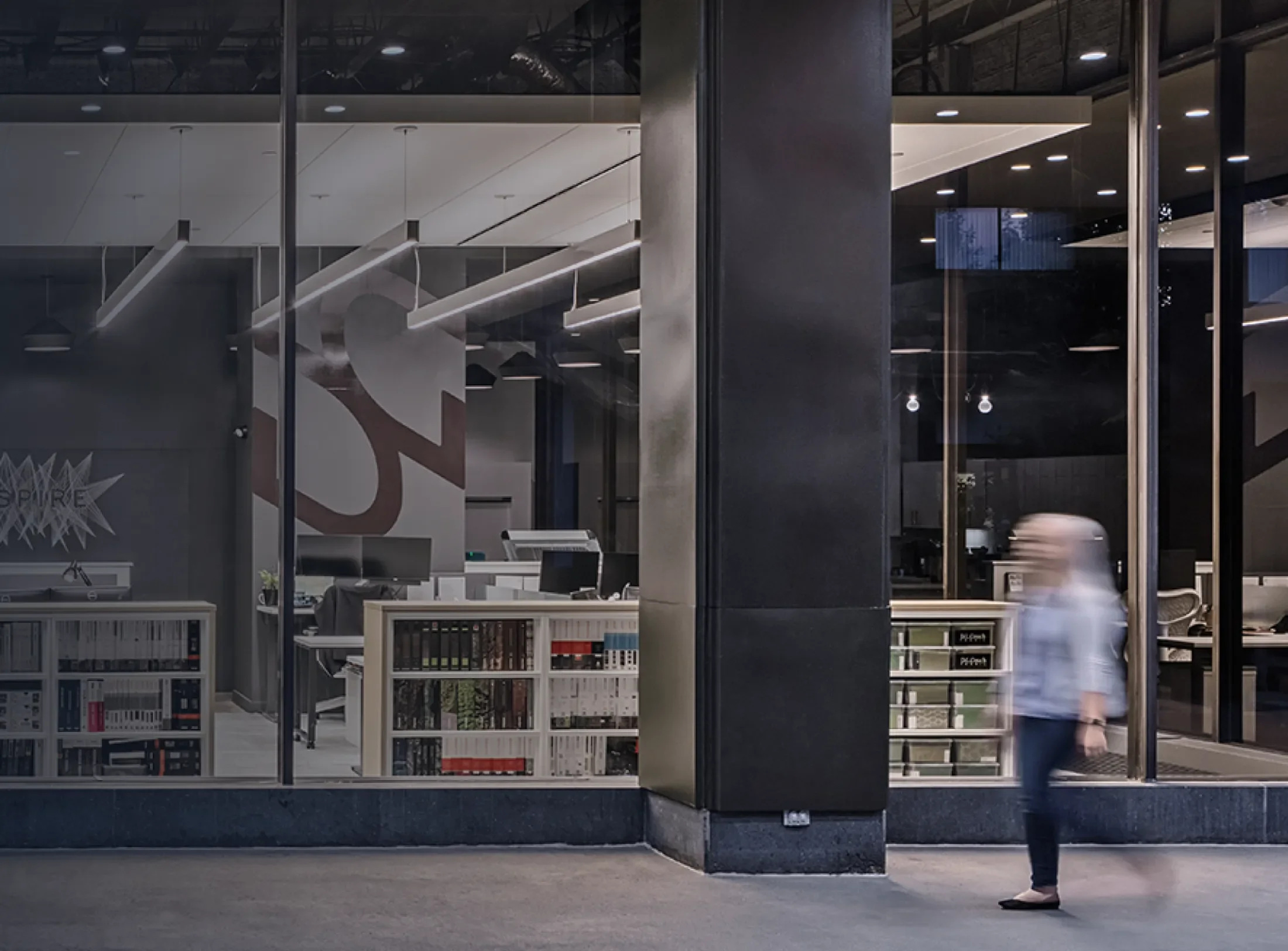 DesignGroup building showing interior of office with person walking by large windows.