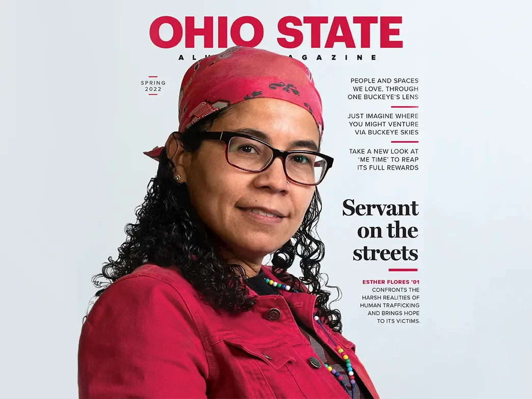 the cover of an ohio state alumni magazine with a woman in a red button up shirt and red baseball cap on