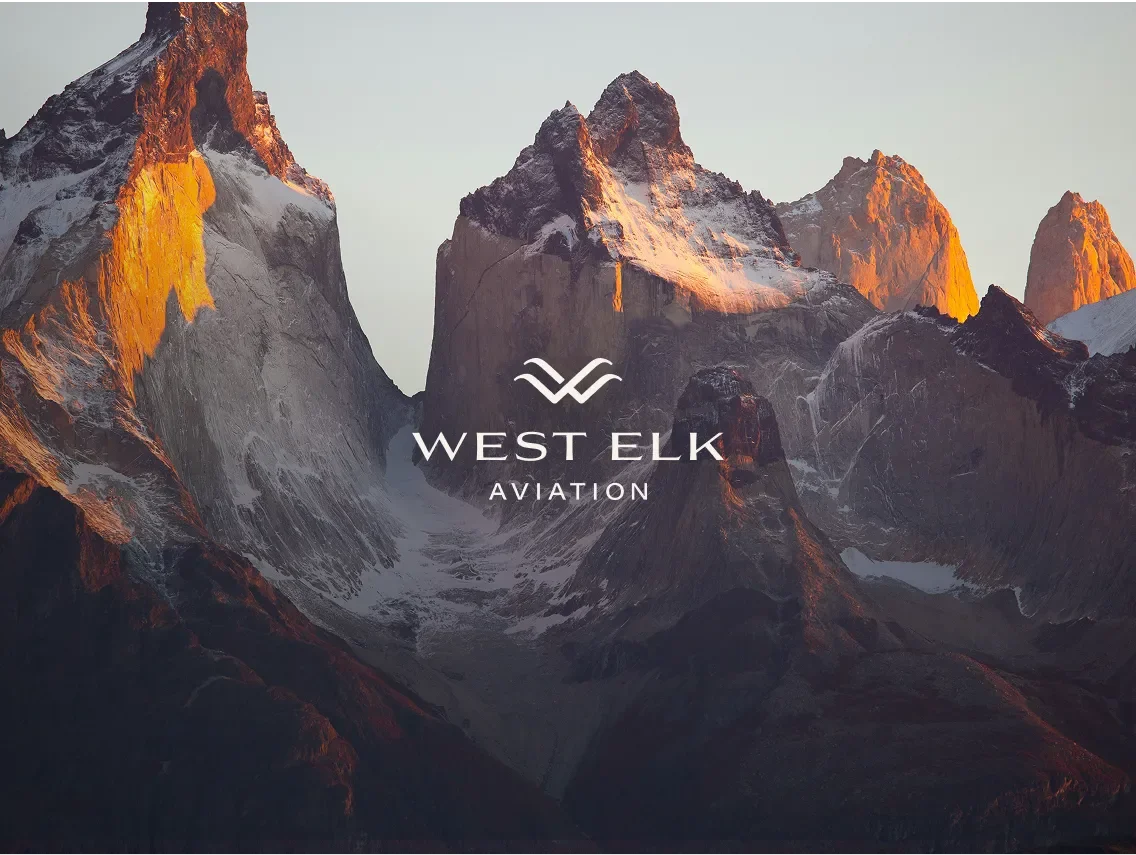 Mountainous landscape at sunset, west elk logo positioned in the middle of the frame.