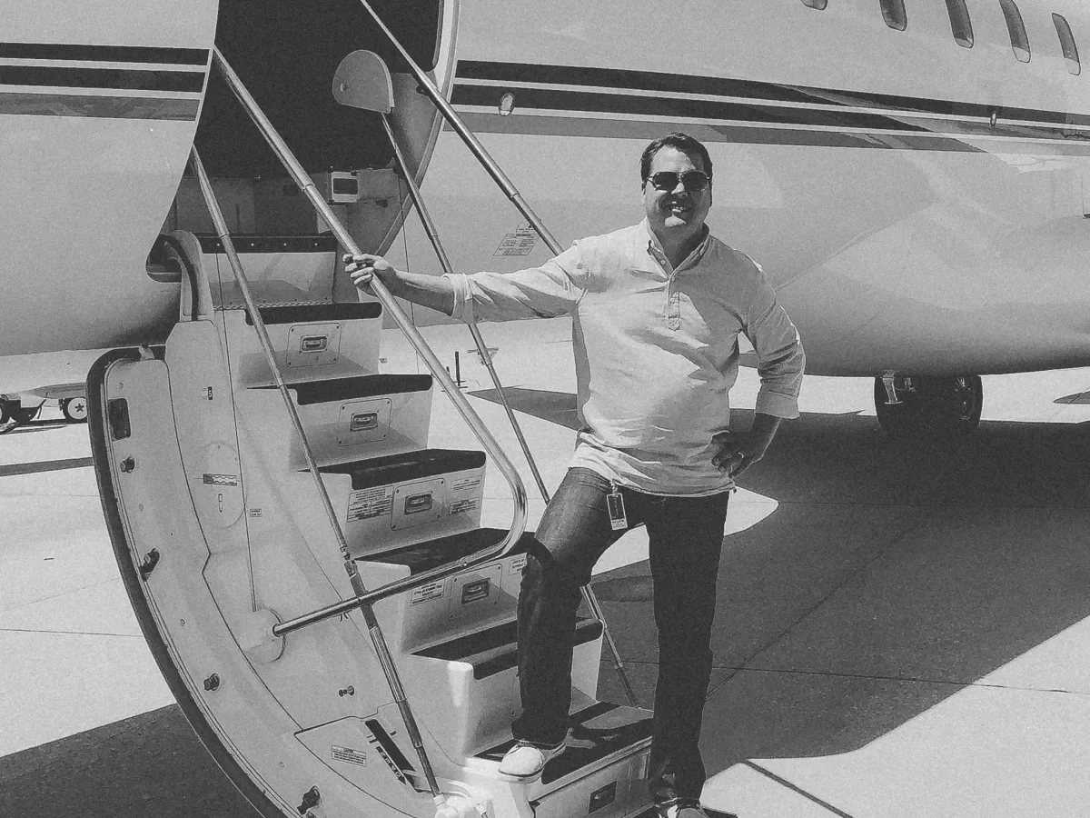Joey standing on the stairs leading into a private jet. 